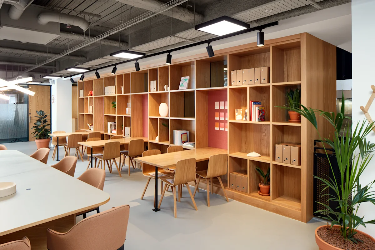 Modern office space with wooden desks, shelves, and plants at New Broad Street 35, London.