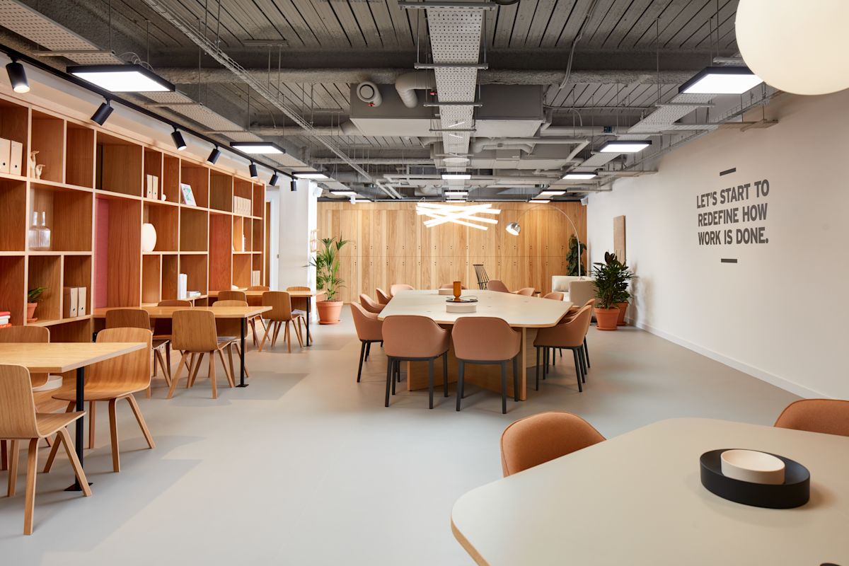 Modern office space on New Broad Street 35 in London with wooden furniture and motivational wall text.