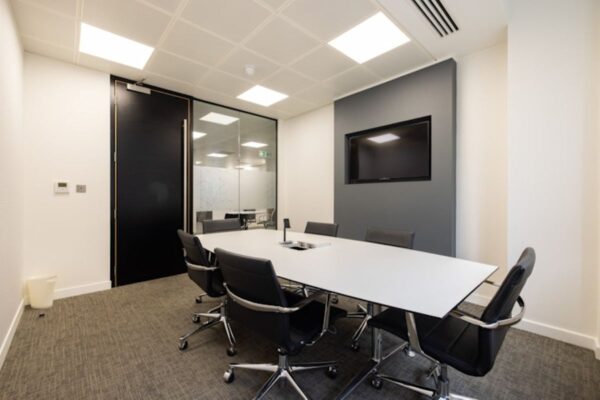 Modern meeting room with a long table and office chairs, located at 42 New Broad Street, London.