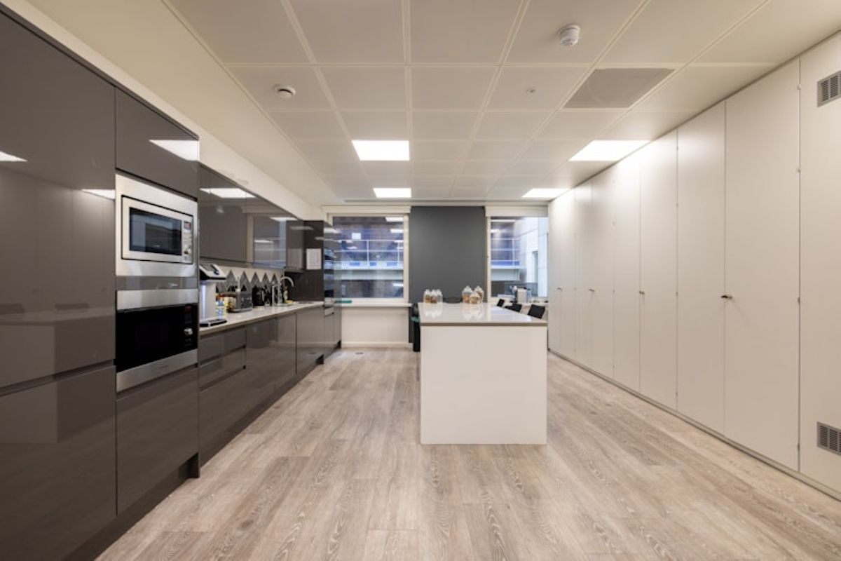 Modern office kitchen with sleek cabinets and a central island at New Broad Street 42, London.