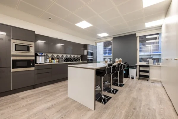 Modern kitchen with grey cabinets and bar seating at New Broad Street 42, London.
