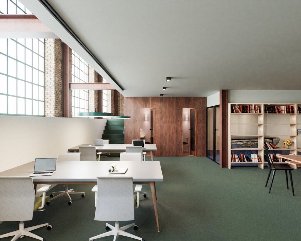 A modern office space with desks, chairs, laptops, and bookshelves, located at New Inn Yard 44-46 in London.