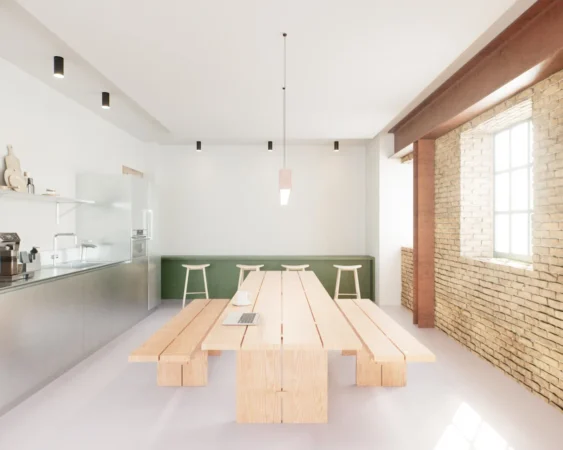 A bright, modern kitchen with a long wooden table, minimalist design, and exposed brick walls.