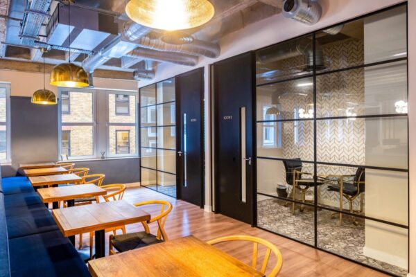 Modern office space with wooden tables, chairs, and glass partitions at New Street 14, London.
