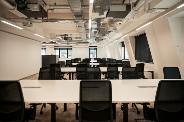 A modern, empty office space with rows of desks and chairs, located at Norton Folgate 1, London.