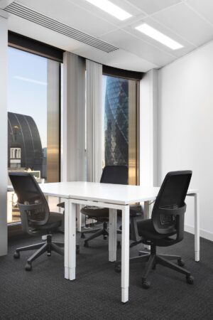 A modern office with three chairs and a table, overlooking London landmarks from large windows.