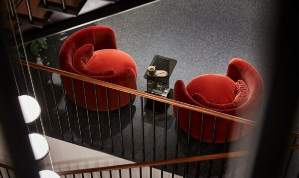 Two plush red armchairs with a small table in between, seen from above.