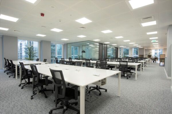 Modern office space with rows of desks and chairs inside One Canada Square, London.