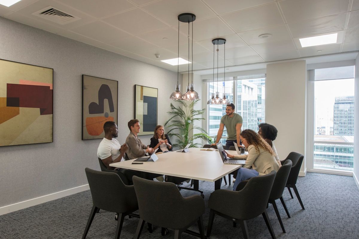 A group of people having a meeting in a modern conference room at One Canada Square, London.