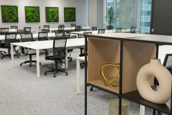 A modern office space in One Canada Square with white desks, black chairs, and decorative art pieces.