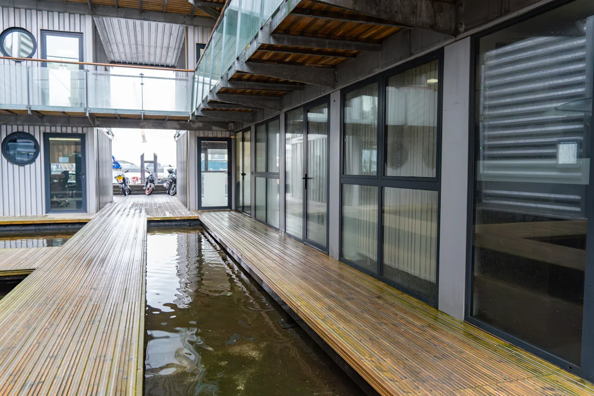Walkway beside modern glass and metal architecture at Orchard Place 64, London.