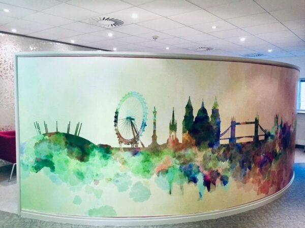 A curved wall with a colorful watercolor mural of London's skyline.