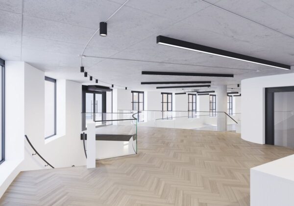 A spacious, modern interior of an office building on Phipp Street in London with large windows, a wooden floor, and sleek lighting fixtures.
