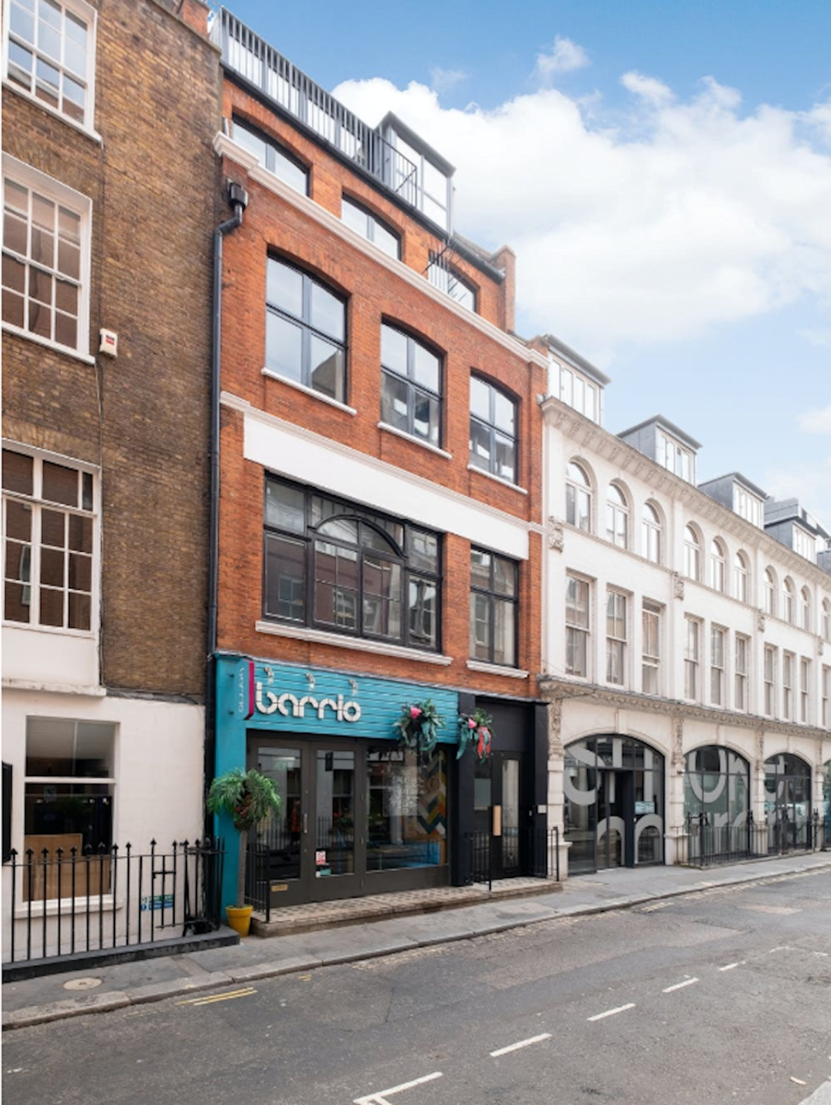 Street view of a building on Poland Street 6, London, featuring a façade with a shop on the ground floor.