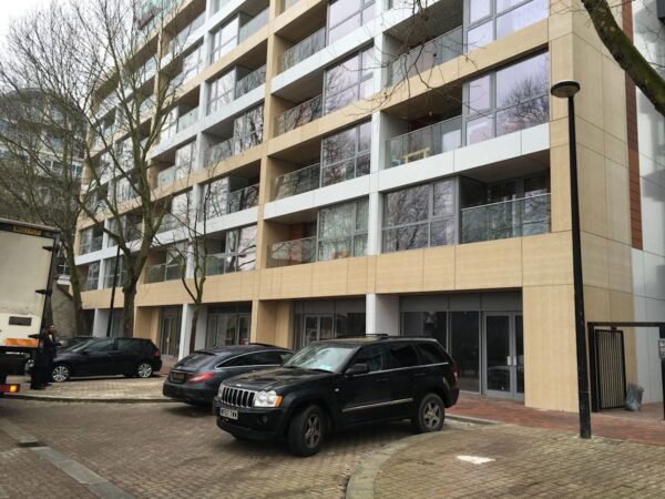 Modern apartment building on Rope Street in London with parked cars in front.