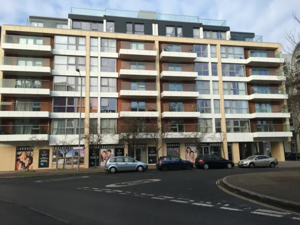 A modern apartment building on Rope Street in London, with several cars parked in front.