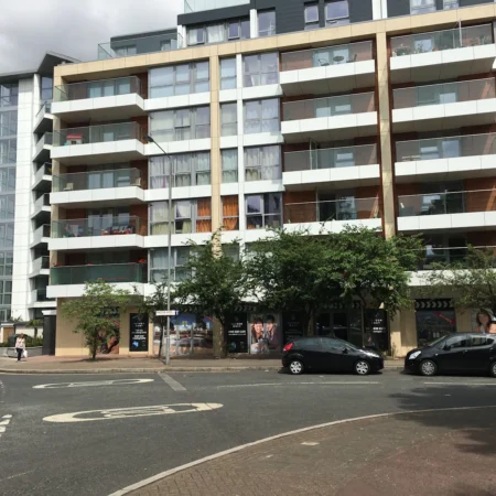 Modern apartment building on Rope Street, London, with parked cars in front.