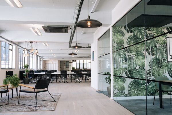 Modern office interior with open workspace and leafy wall design at Scrutton Street, London.