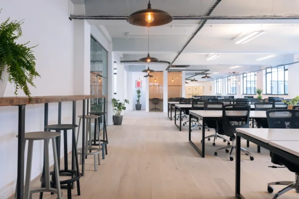 Modern open-plan office space with desks, chairs, and large windows at Scrutton Street 32-38, London.