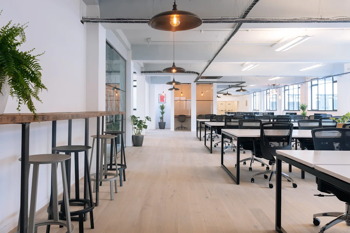 Modern open-plan office space with desks, chairs, and large windows at Scrutton Street 32-38, London.