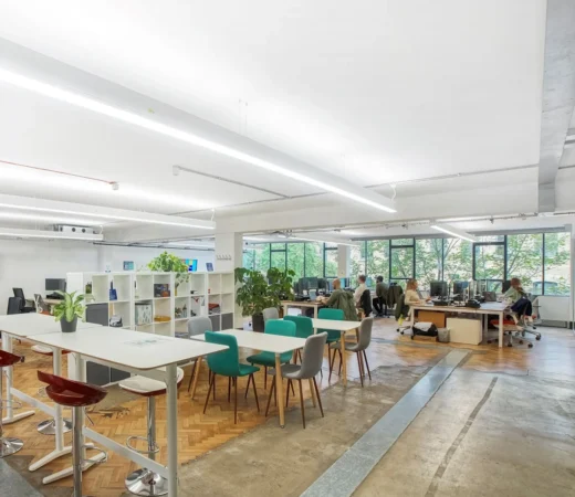 Modern open-plan office interior with desks, chairs, and large windows at Scrutton Street, London.