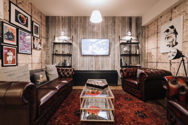 Cozy living room with leather sofas, eclectic wall art, and a central glass coffee table.