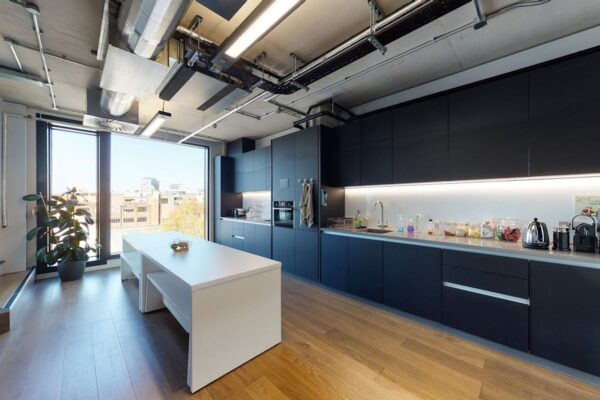Modern kitchen interior with dark cabinets and a large window overlooking Shoreditch High Street in London.