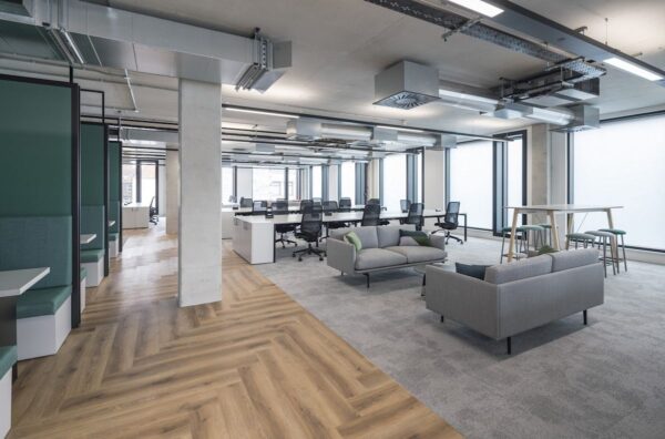 Modern open-plan office space with desks, chairs, and casual seating in Shoreditch High Street, London.