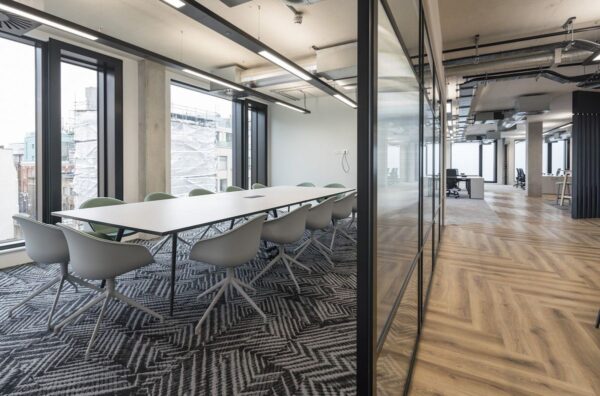 Modern office interior with large windows and a meeting room table at Shoreditch High Street 168, London.