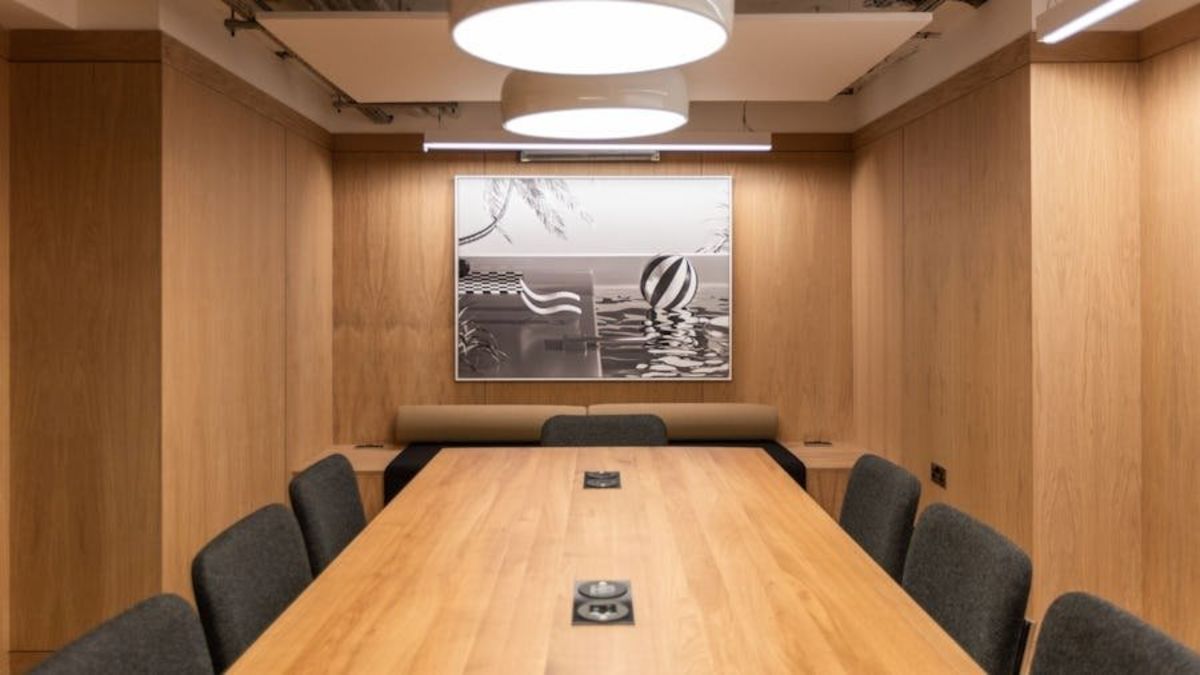 A modern conference room at St Helens Place 17 in London with wooden walls and a central artwork.