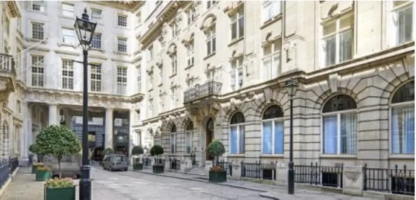 A view of a historic building facade on St Helens Place in London, featuring ornate architecture and a cobblestone street.