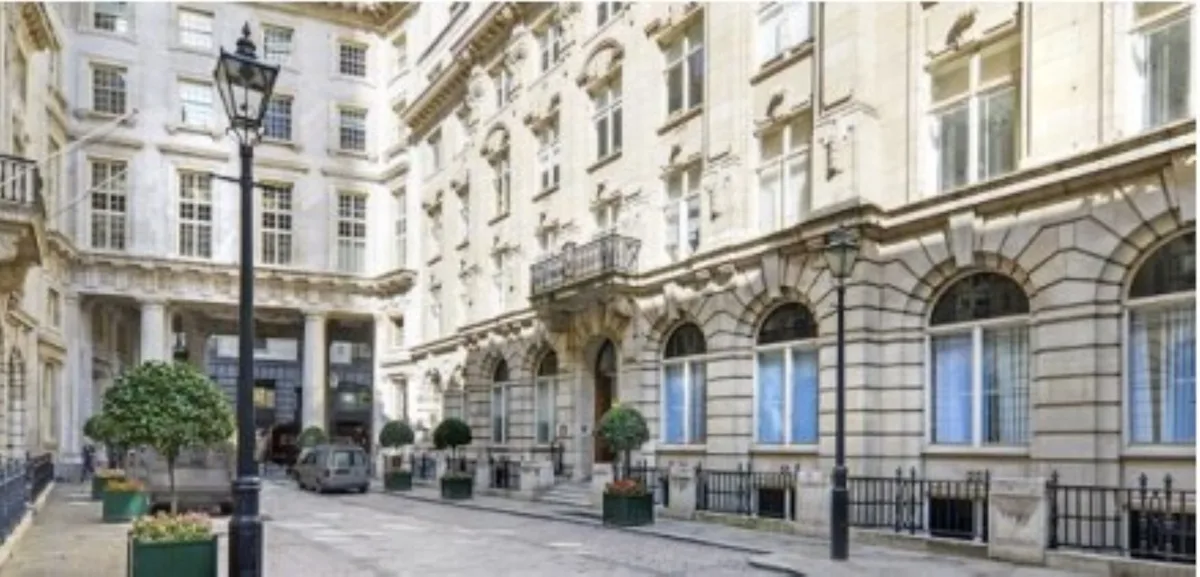 A view of a historic building facade on St Helens Place in London, featuring ornate architecture and a cobblestone street.