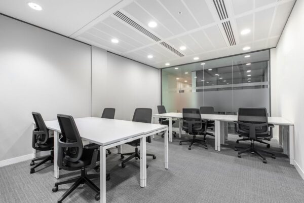 Modern office space with white desks and black chairs at St Mary Axe 63, London.
