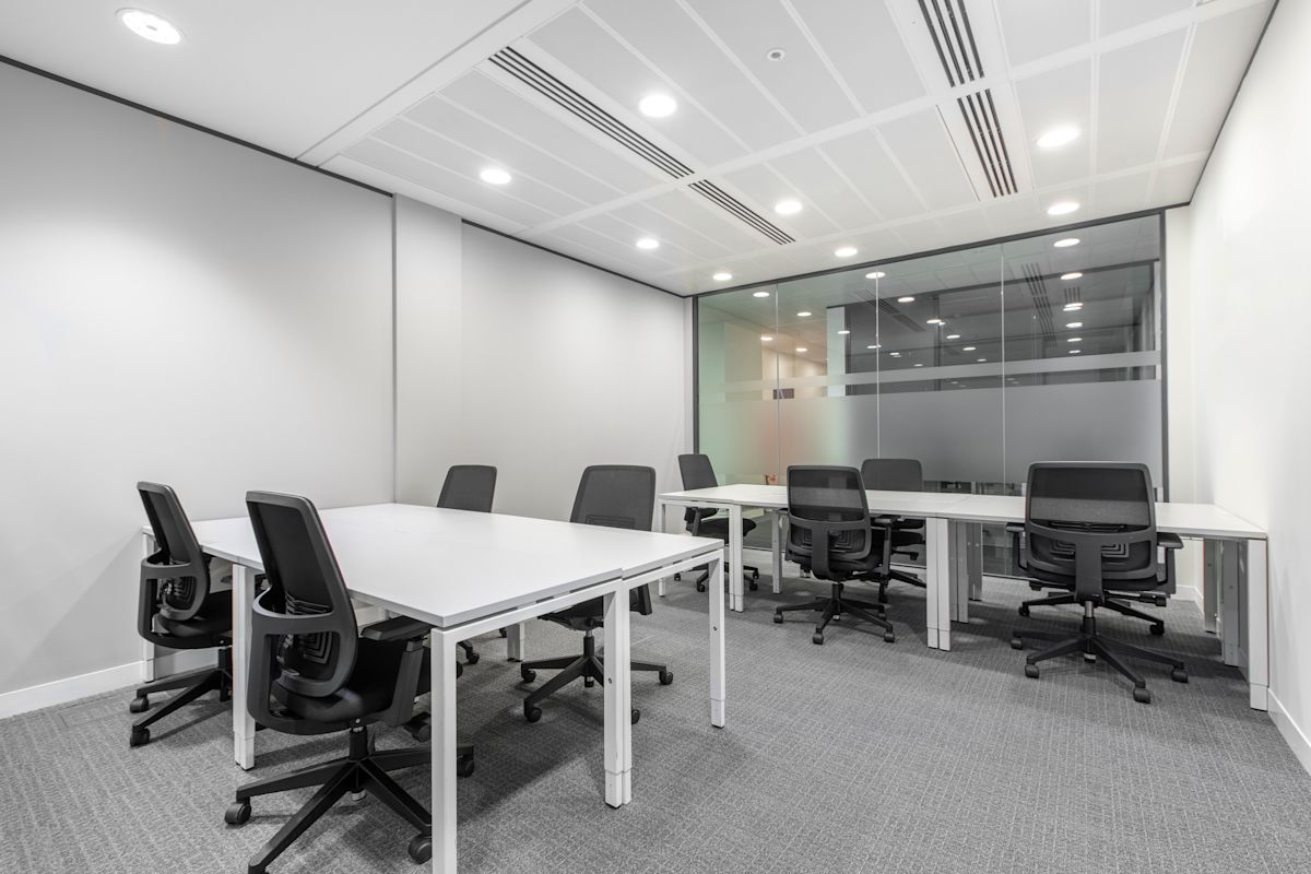 Modern office space with white desks and black chairs at St Mary Axe 63, London.