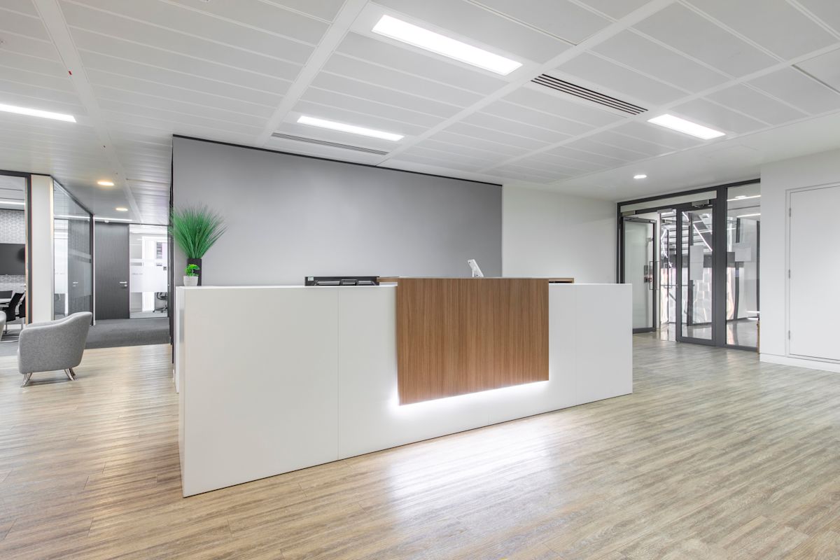 Modern office reception area with a sleek desk and minimalist decor.