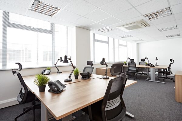 Modern office workspace with desks, chairs, and plants on Victoria Avenue, London.