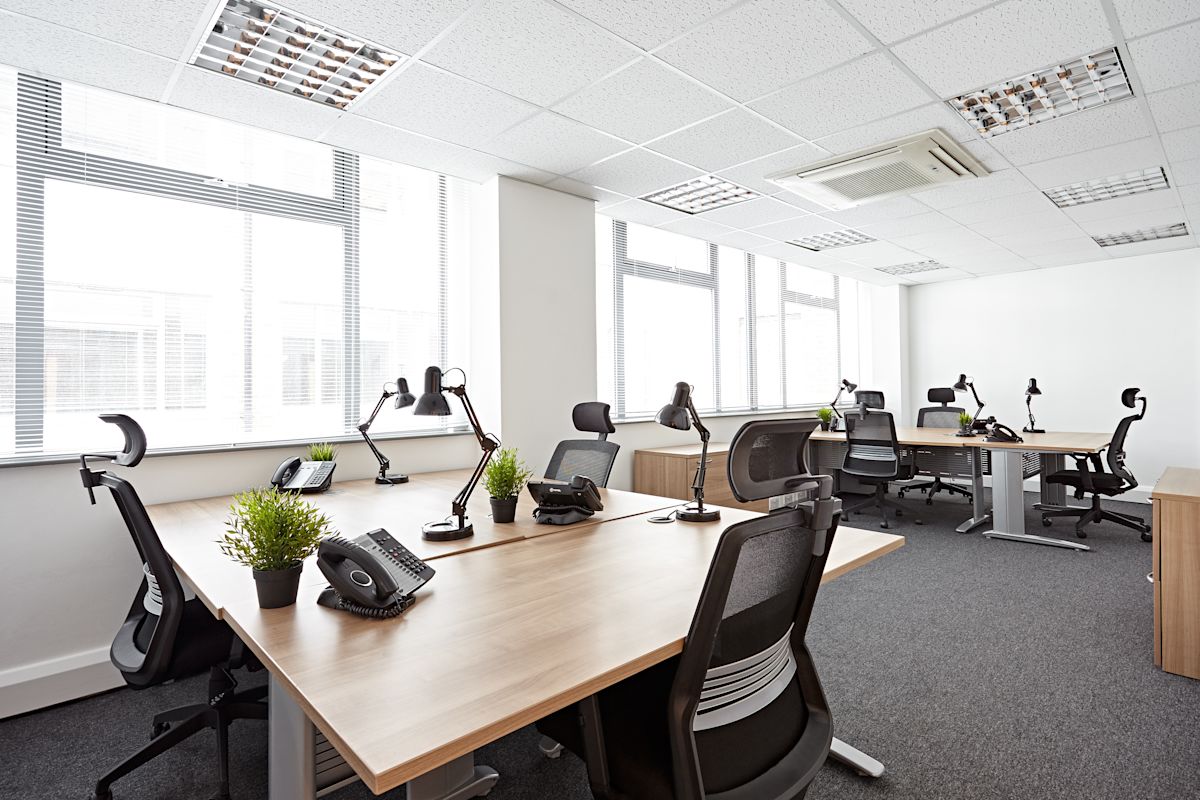 Modern office workspace with desks, chairs, and plants on Victoria Avenue, London.