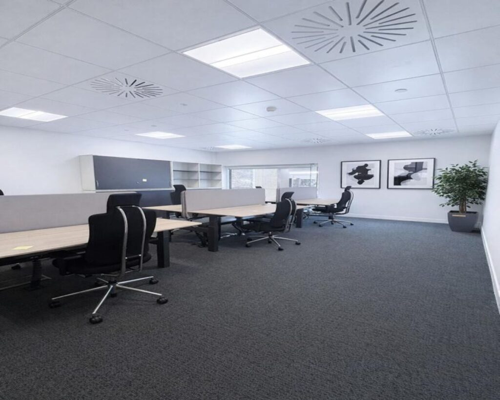 A modern, spacious office interior with several desks, office chairs, and minimalist decor.