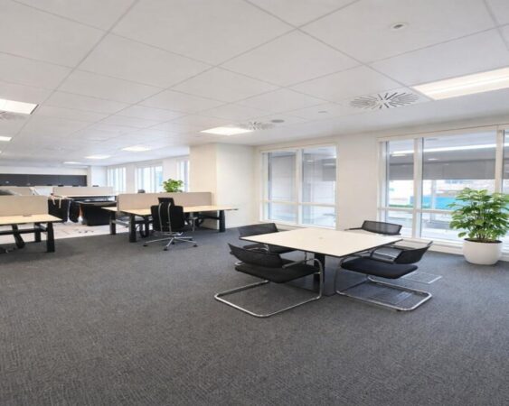 A modern office space at Westferry Circus 11 London, featuring desks, chairs, and large windows.