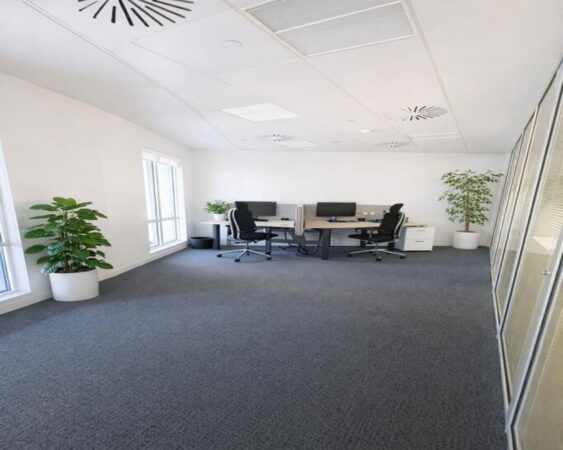 A modern office space in Westferry Circus 11, London, featuring desks, office chairs, and potted plants.