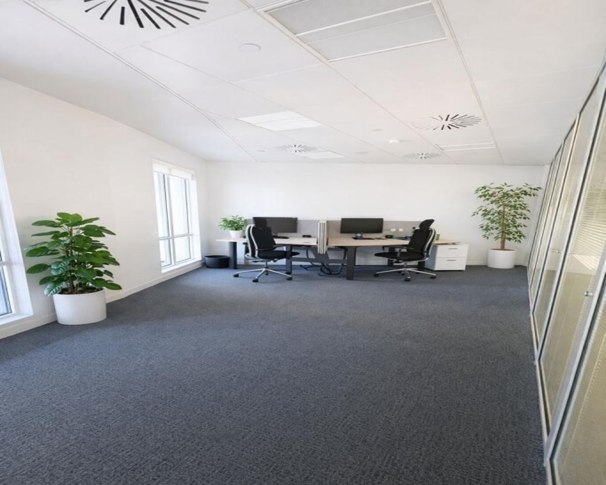 A modern office space in Westferry Circus 11, London, featuring desks, office chairs, and potted plants.