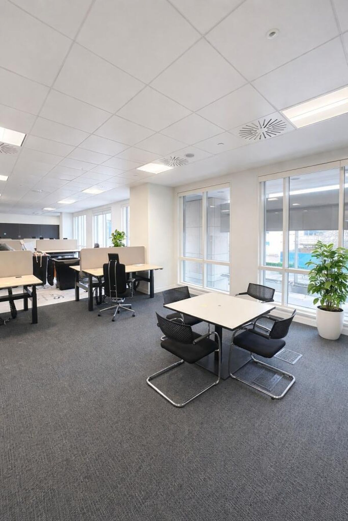 A modern office space with desks, chairs, and large windows at Westferry Circus 11, London.