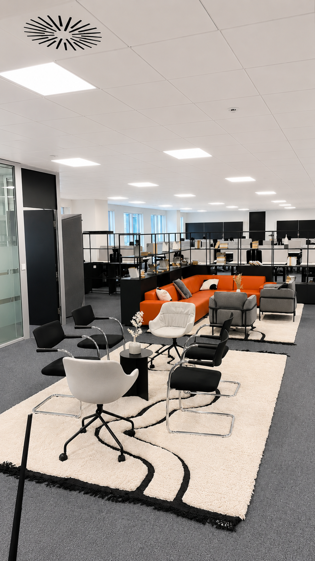 Modern office lounge area with colorful seating and bookshelves at Westferry Circus, London.
